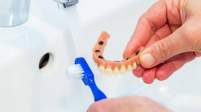 cleaning-dentures-in-sink-846x473