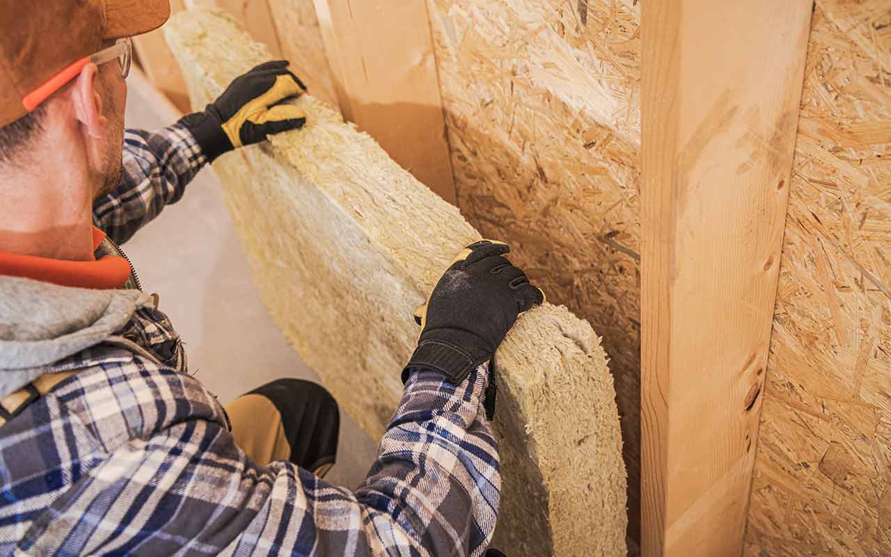 contractor-installing-mineral-wool-insulator